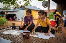 Two girls studying around the radio